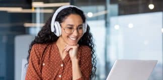 Progresser rapidement grâce au soutien scolaire en ligne étudiante qui regarde et écoute un cours de soutien scolaire en ligne