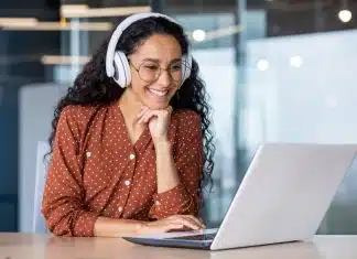 Progresser rapidement grâce au soutien scolaire en ligne étudiante qui regarde et écoute un cours de soutien scolaire en ligne